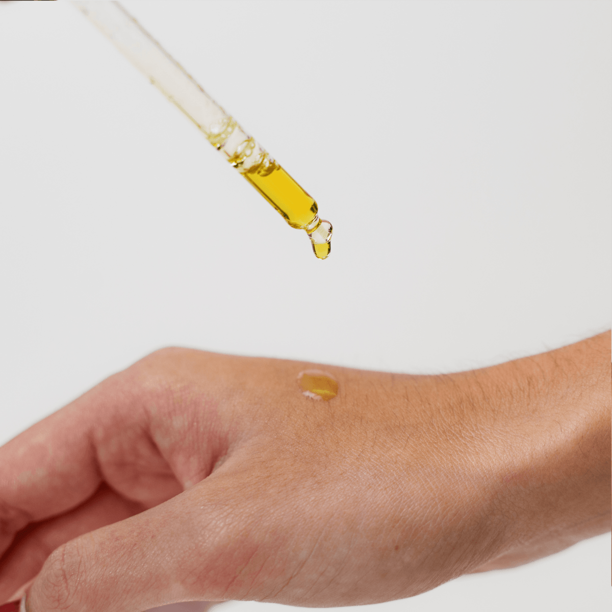 using Skin Care Oil - drop of CBD oil on hand